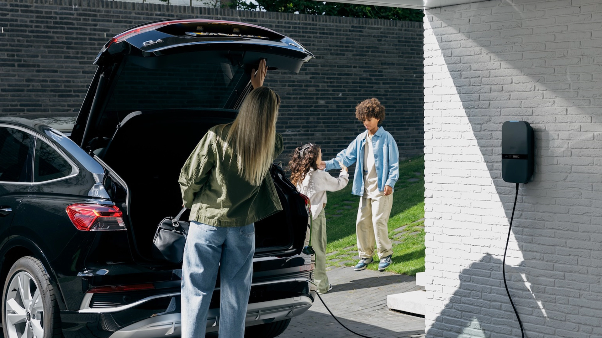 Gezin bij een elektrische auto en thuislaadpaal
